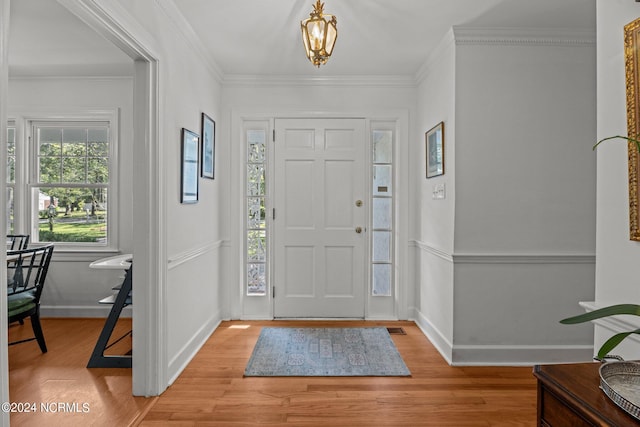 entrance foyer featuring ornamental molding and hardwood / wood-style floors