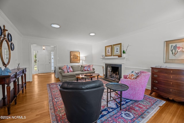 living room with ornamental molding and light hardwood / wood-style flooring