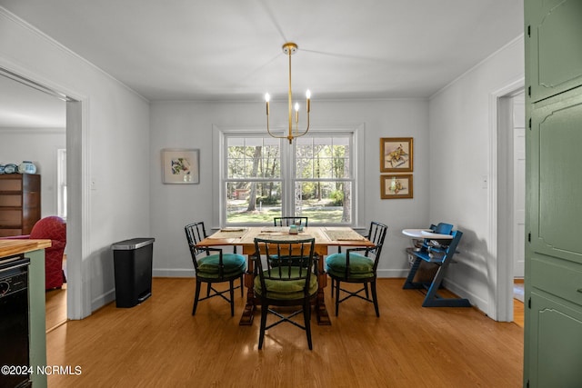 dining room featuring a notable chandelier, crown molding, and light hardwood / wood-style floors