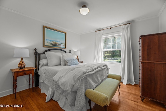 bedroom with hardwood / wood-style flooring and ornamental molding