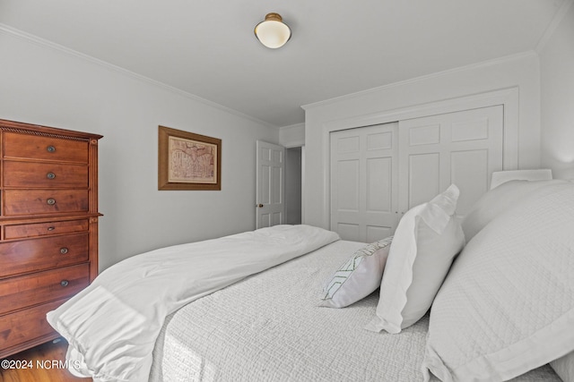 bedroom featuring a closet, crown molding, and hardwood / wood-style flooring