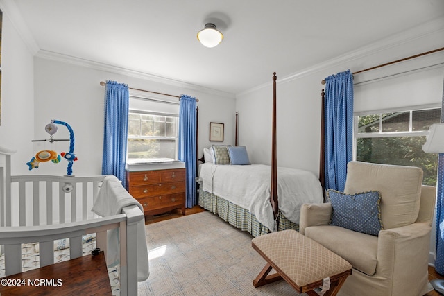 bedroom with hardwood / wood-style flooring, multiple windows, and crown molding