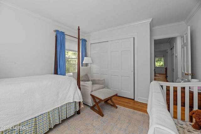 bedroom featuring a closet, crown molding, and light hardwood / wood-style floors