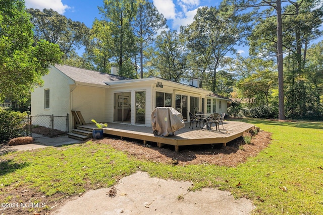 back of property with a lawn and a wooden deck