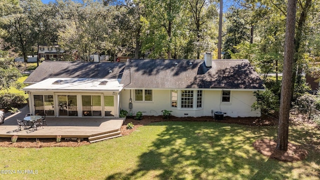 back of house featuring a wooden deck and a lawn