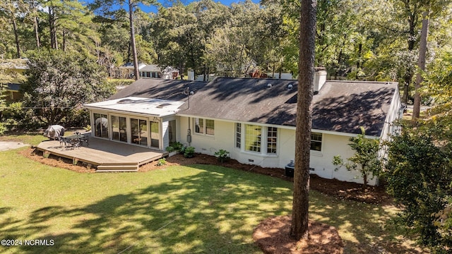 rear view of house featuring a deck and a yard