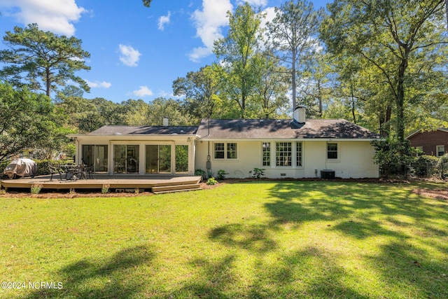 back of property featuring a deck and a yard