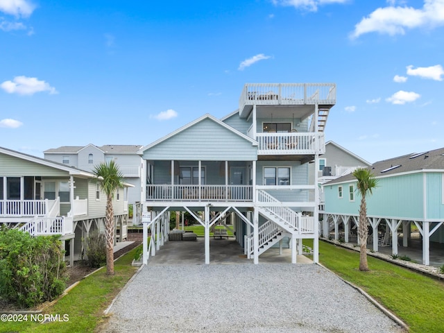 beach home featuring a carport, a balcony, and a sunroom