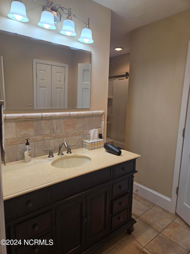 bathroom with vanity, tile patterned flooring, and decorative backsplash