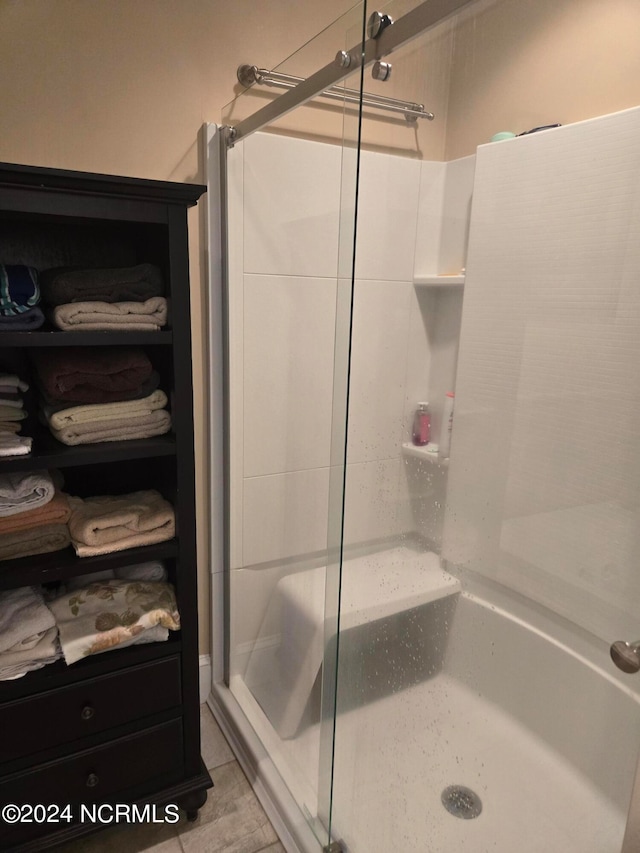 bathroom with tile patterned floors and a shower with shower door