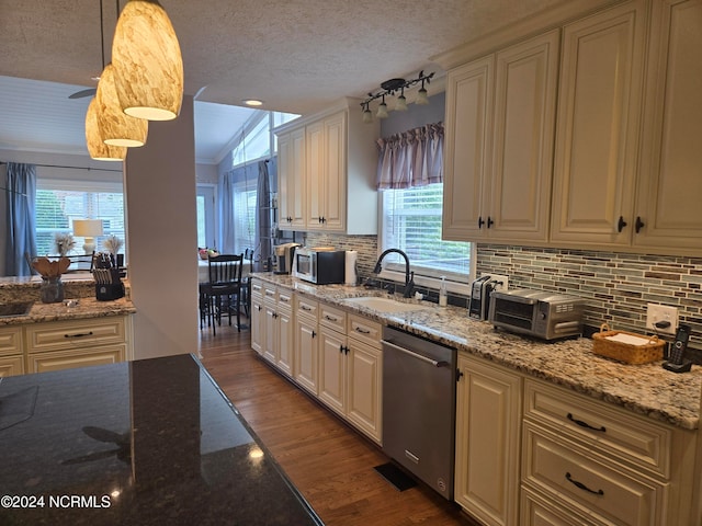 kitchen with pendant lighting, sink, a healthy amount of sunlight, and stainless steel dishwasher