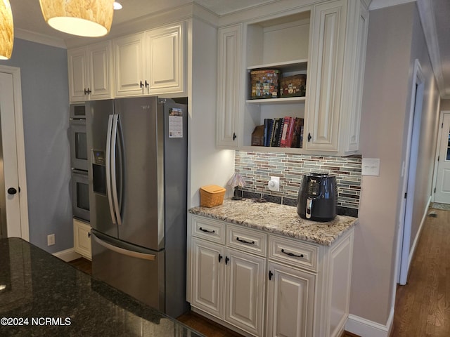 kitchen with tasteful backsplash, white cabinetry, stainless steel appliances, light stone countertops, and dark hardwood / wood-style flooring