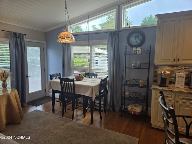 dining area featuring a healthy amount of sunlight, lofted ceiling, ornamental molding, and dark hardwood / wood-style flooring