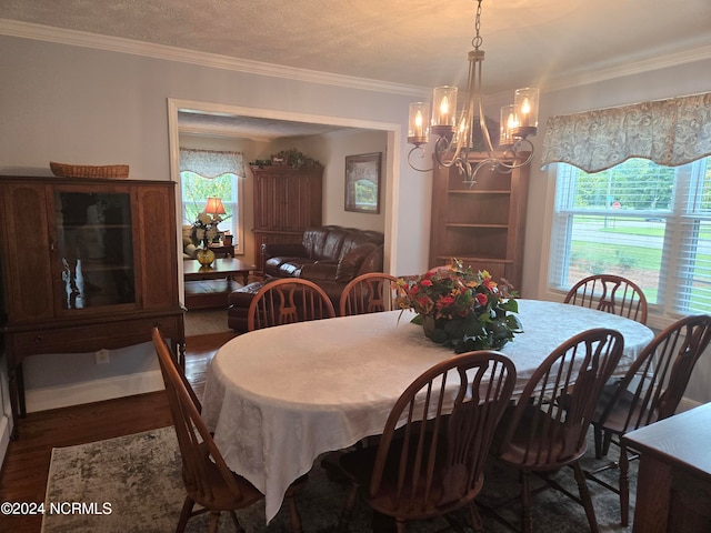 dining space with ornamental molding, a wealth of natural light, a chandelier, and dark hardwood / wood-style flooring