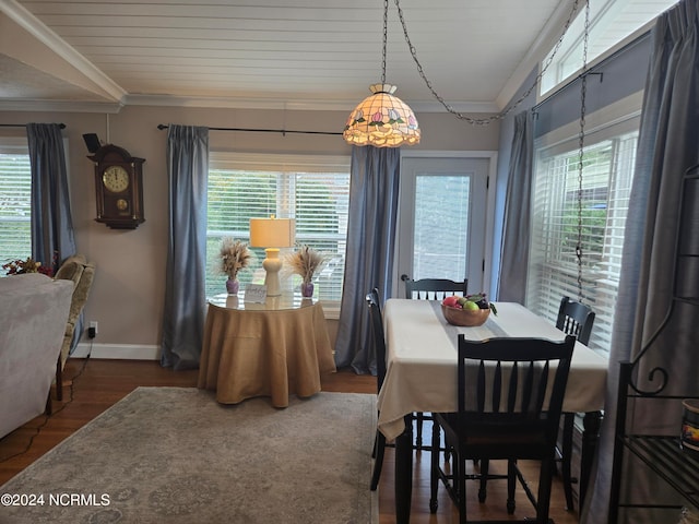 dining room featuring a wealth of natural light, crown molding, and dark hardwood / wood-style flooring