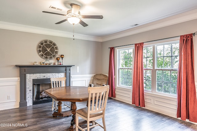 dining area featuring ornamental molding, ceiling fan, dark hardwood / wood-style floors, and a fireplace