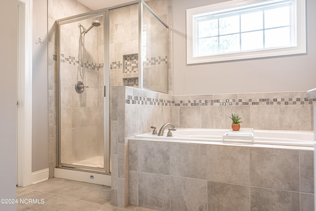 bathroom featuring independent shower and bath, tile patterned flooring, and a healthy amount of sunlight