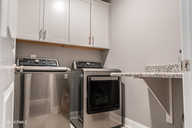 laundry room featuring cabinets and washing machine and clothes dryer