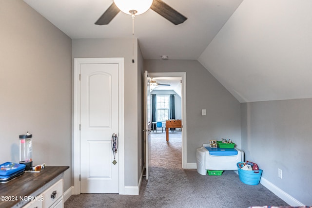 interior space with ceiling fan, carpet floors, and vaulted ceiling