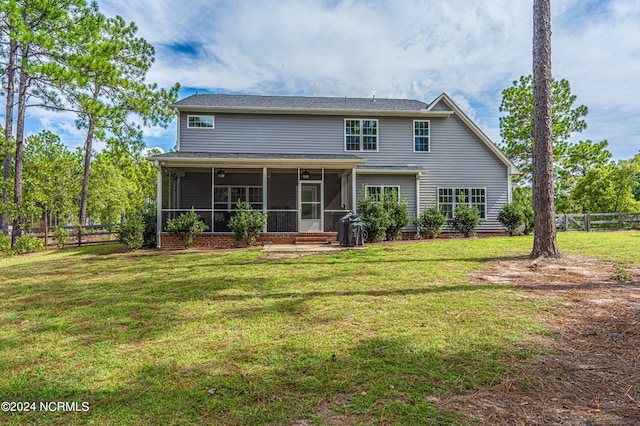 rear view of house with a sunroom and a lawn