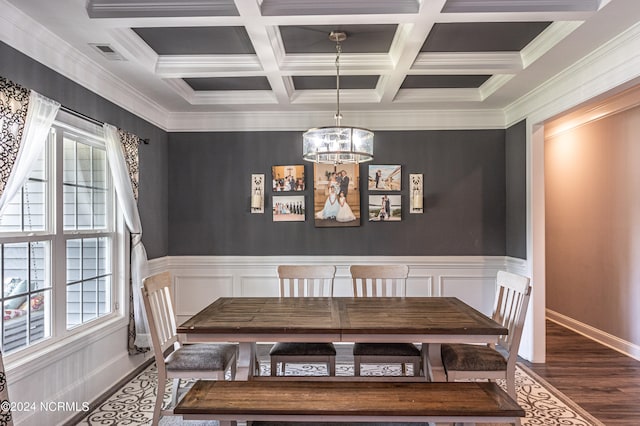 unfurnished dining area featuring beamed ceiling, coffered ceiling, dark hardwood / wood-style floors, an inviting chandelier, and crown molding