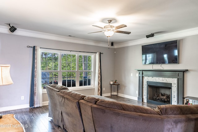 living room featuring a fireplace, ornamental molding, dark wood-type flooring, and ceiling fan