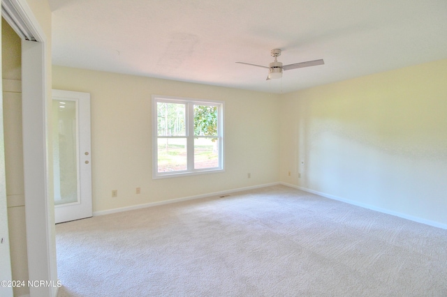 carpeted spare room featuring ceiling fan