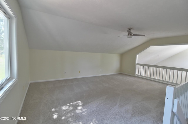 additional living space featuring carpet, vaulted ceiling, ceiling fan, and a healthy amount of sunlight