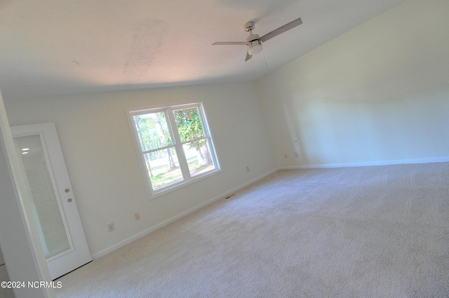 empty room featuring ceiling fan, light colored carpet, and lofted ceiling