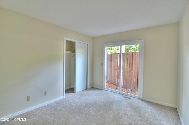 unfurnished bedroom with light carpet and a closet