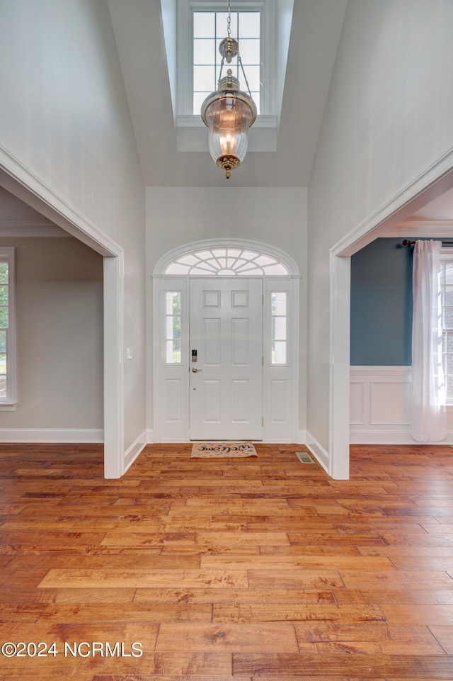 foyer with a wealth of natural light, a chandelier, and light hardwood / wood-style floors