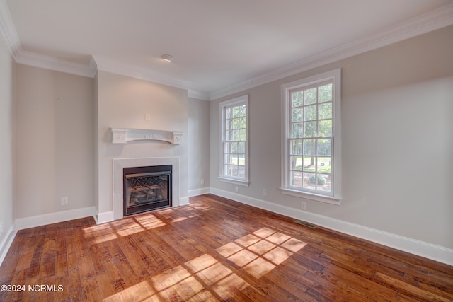 unfurnished living room with ornamental molding and hardwood / wood-style flooring