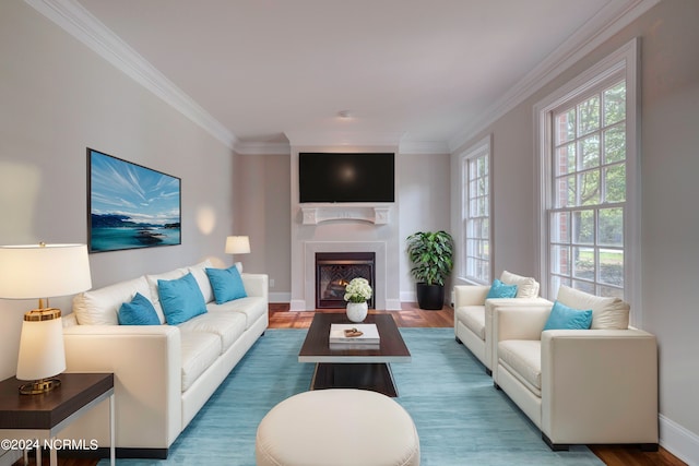 living room with hardwood / wood-style flooring, crown molding, and plenty of natural light