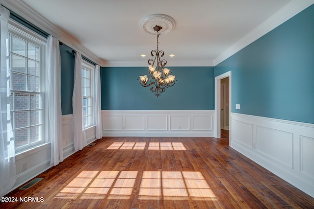 spare room with ornamental molding, a notable chandelier, and dark hardwood / wood-style flooring