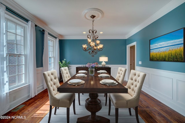 dining room featuring ornamental molding, dark wood-type flooring, and a chandelier