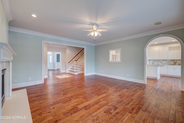 unfurnished living room featuring crown molding, wood-type flooring, and ceiling fan