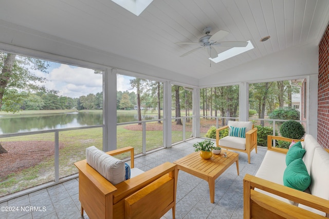 sunroom with ceiling fan, vaulted ceiling with skylight, a water view, and a wealth of natural light