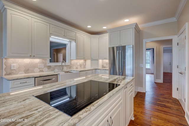 kitchen with stainless steel fridge, light stone counters, white cabinets, black electric stovetop, and dark hardwood / wood-style floors