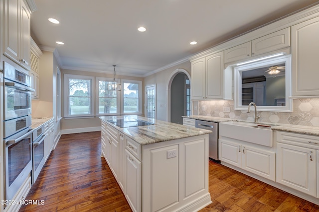140 River Woods Dr, Wallace, NC 28466 - kitchen featuring a sink, appliances with stainless steel finishes, a center island, white cabinets, and ornamental molding