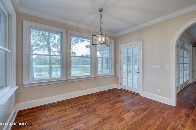 unfurnished dining area with ornamental molding, a notable chandelier, and dark hardwood / wood-style floors