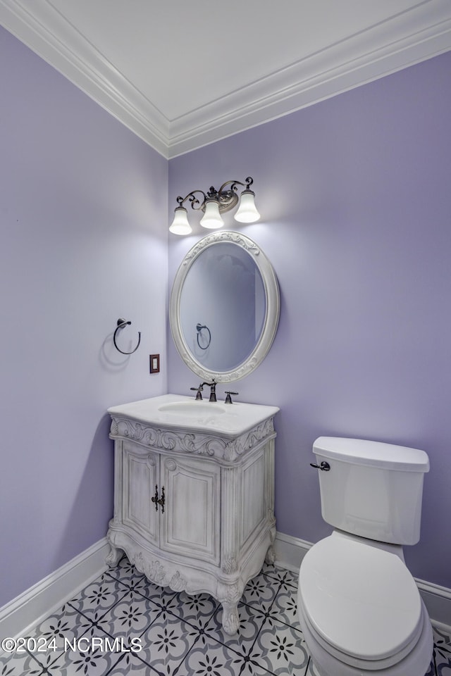 bathroom with ornamental molding, toilet, vanity, and tile patterned floors