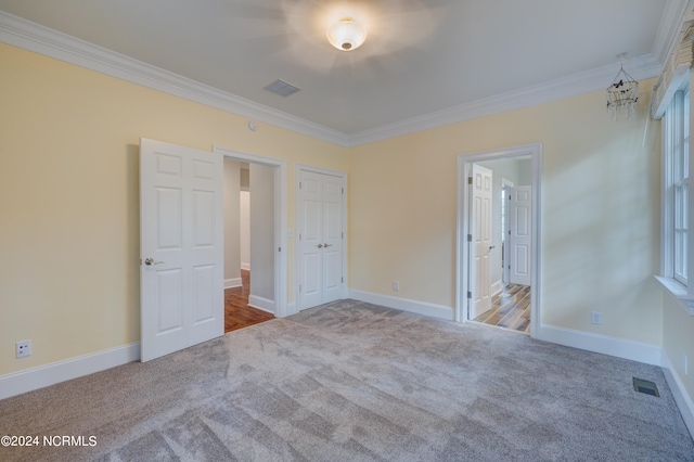 unfurnished bedroom with light carpet, ensuite bath, and crown molding