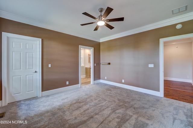 unfurnished bedroom with ceiling fan, ensuite bath, ornamental molding, and carpet