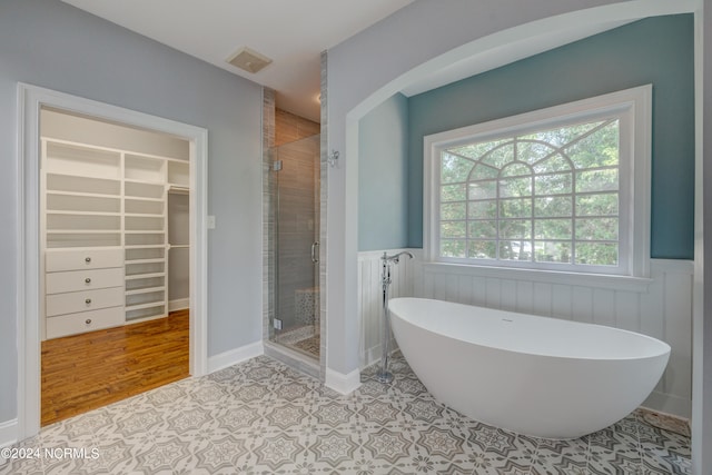 bathroom with independent shower and bath and hardwood / wood-style flooring