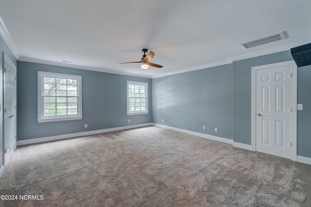 spare room featuring ceiling fan, light colored carpet, plenty of natural light, and ornamental molding