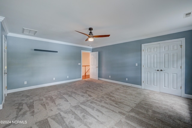 carpeted empty room with ceiling fan and crown molding