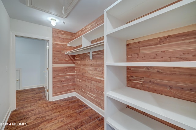 spacious closet with hardwood / wood-style flooring