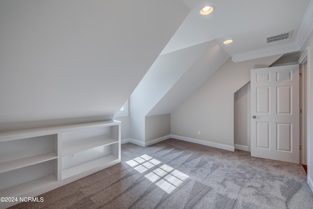 bonus room with vaulted ceiling and light colored carpet