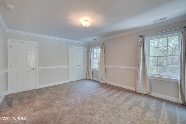 empty room with light carpet, crown molding, and a healthy amount of sunlight