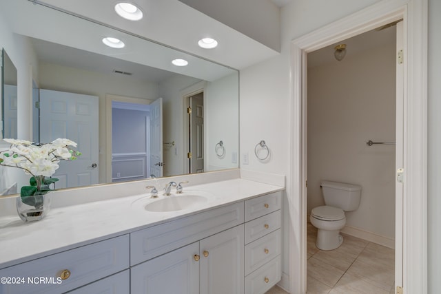 bathroom featuring vanity, tile patterned flooring, and toilet